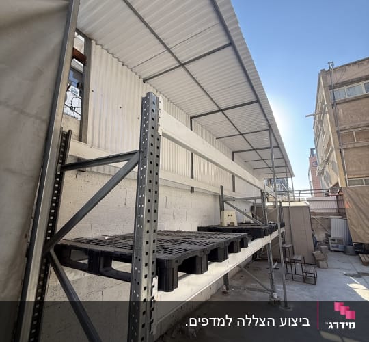 התקנת סוכך קבוע משלד מתכת וקירוי גלי מעל אזור אחסון